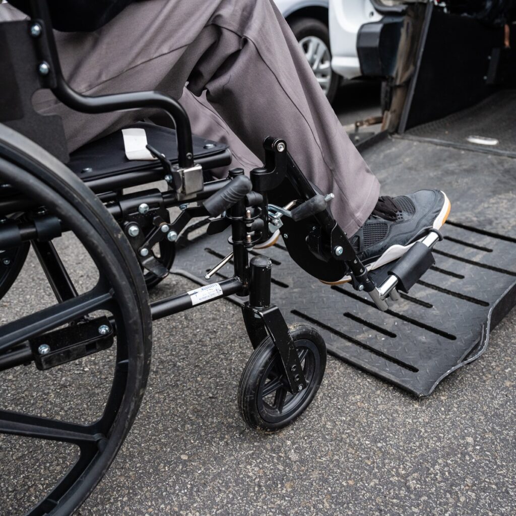 a man in a wheelchair onto a ramp of a van