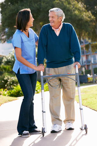 a healthcare worker assisting an old man in a walker