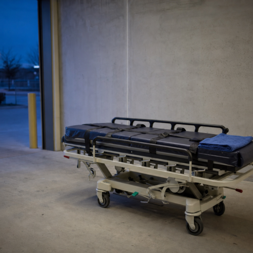 A reinforced heavy-duty stretcher with wide safety straps in a quiet loading bay